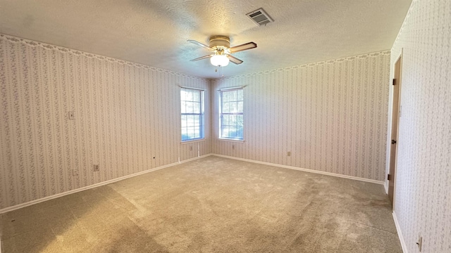 carpeted empty room with a textured ceiling and ceiling fan