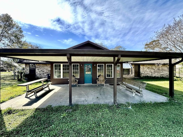 rear view of property featuring a patio and a lawn