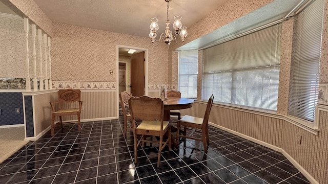 dining area featuring an inviting chandelier and a textured ceiling