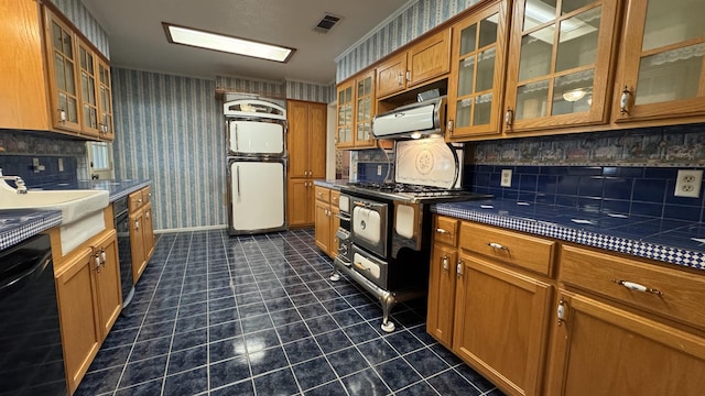 kitchen featuring dishwasher, range with gas stovetop, refrigerator, decorative backsplash, and sink