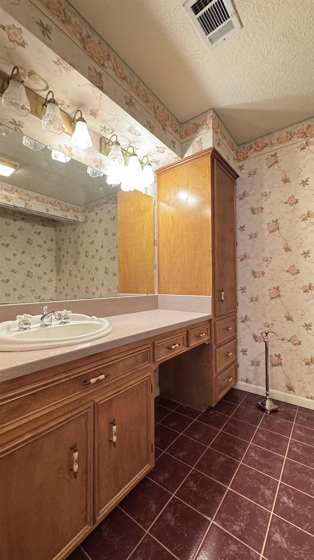 bathroom with tile patterned floors, vanity, and a textured ceiling