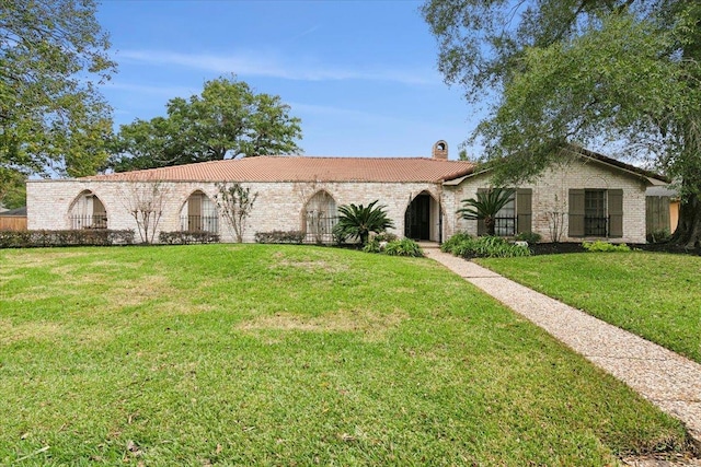 5990 Pinkstaff Ln, Beaumont, TX 77706 - mediterranean / spanish house featuring a tiled roof, a chimney, and a front yard