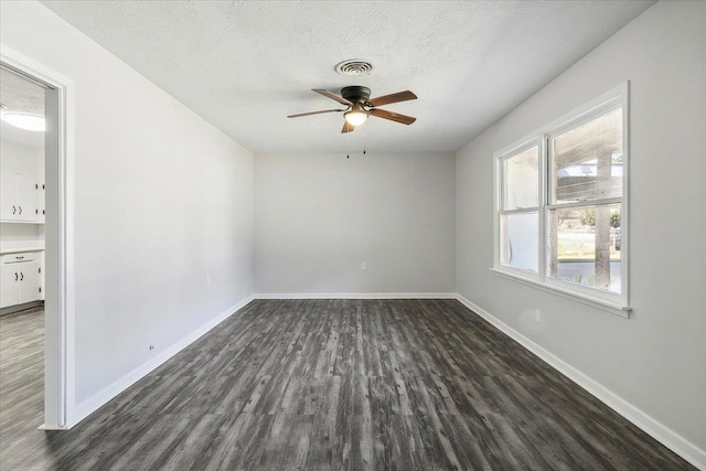 unfurnished room featuring a textured ceiling, ceiling fan, and dark wood-type flooring