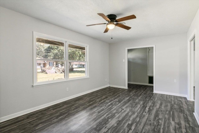 unfurnished room with a textured ceiling, ceiling fan, and dark wood-type flooring