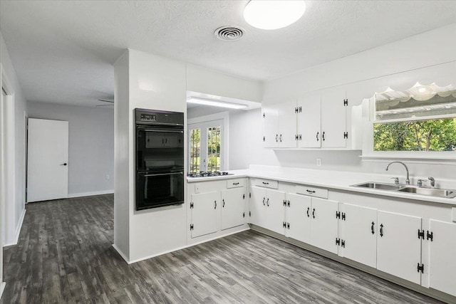 kitchen featuring sink, gas cooktop, double oven, a textured ceiling, and white cabinets