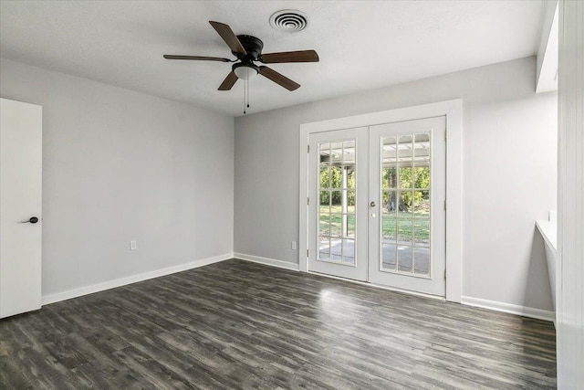 empty room featuring ceiling fan, french doors, and dark wood-type flooring