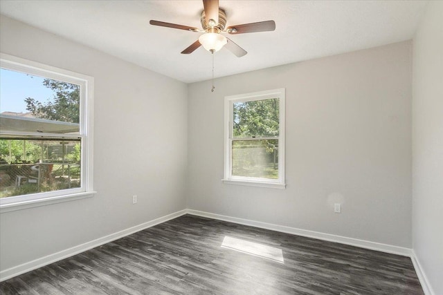 spare room with a wealth of natural light, dark wood-type flooring, and ceiling fan