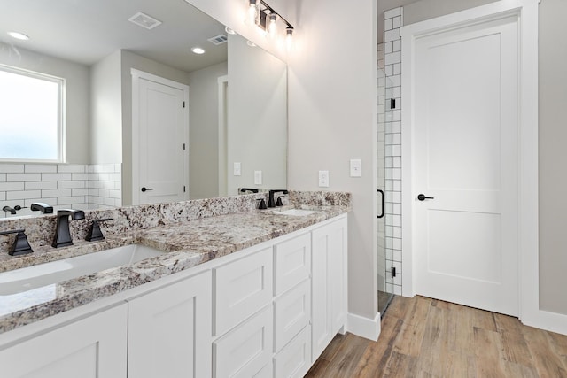 bathroom featuring backsplash, a shower with door, vanity, and wood-type flooring