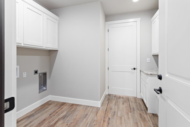 clothes washing area featuring cabinets, light hardwood / wood-style floors, and hookup for an electric dryer