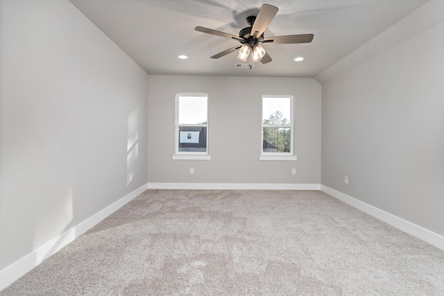 empty room with ceiling fan, light colored carpet, and lofted ceiling