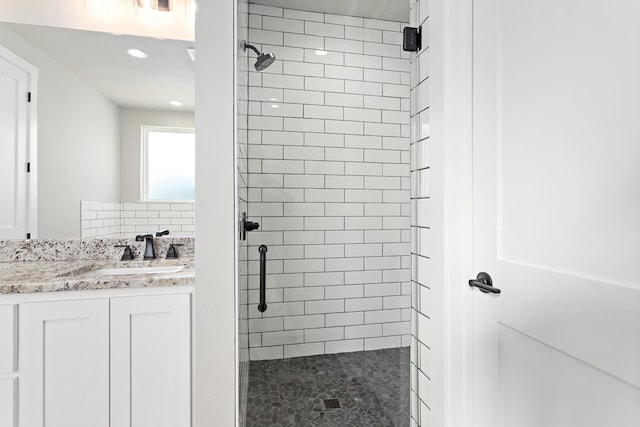 bathroom featuring vanity, tasteful backsplash, and an enclosed shower