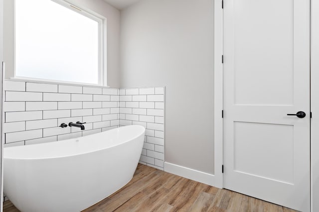 bathroom featuring a bath and wood-type flooring