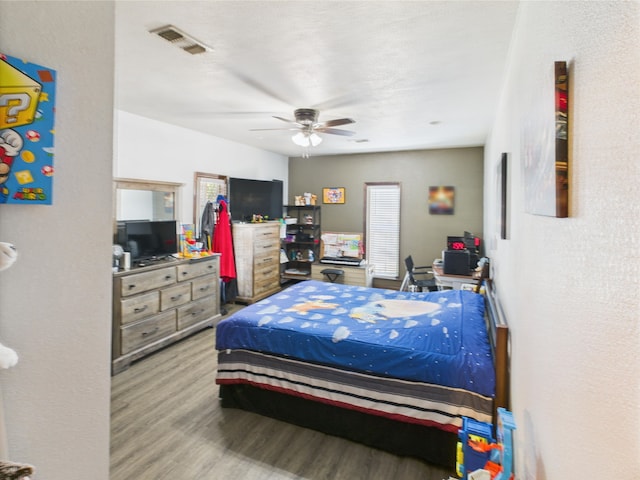 650 Sudduth Dr, Bridge City, TX 77611 - bedroom with wood finished floors, ceiling fan, and a desk