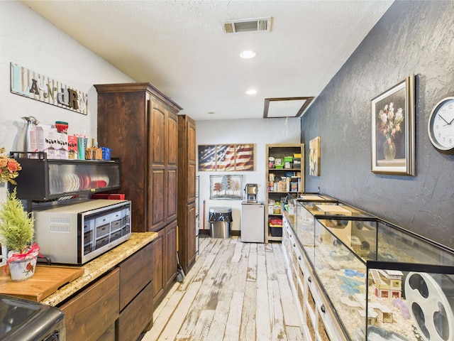 650 Sudduth Dr, Bridge City, TX 77611 - kitchen featuring light wood finished floors, a textured wall, a textured ceiling, refrigerator, and recessed lighting