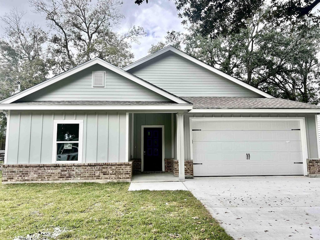 single story home featuring a front lawn and a garage