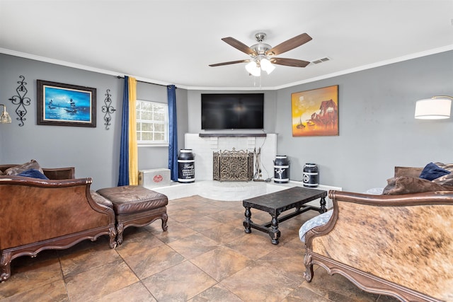 living area featuring a brick fireplace, visible vents, a ceiling fan, and ornamental molding