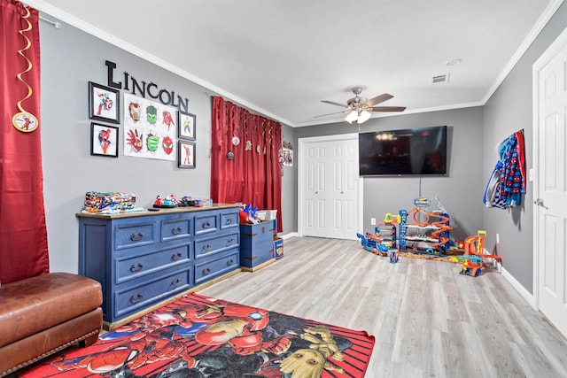 playroom with ceiling fan, baseboards, crown molding, and wood finished floors