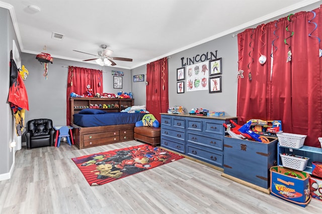 bedroom with ornamental molding, wood finished floors, visible vents, and a ceiling fan