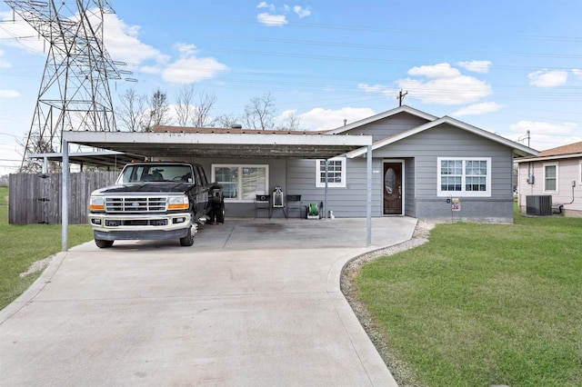 view of front of home with brick siding, concrete driveway, fence, cooling unit, and a front lawn