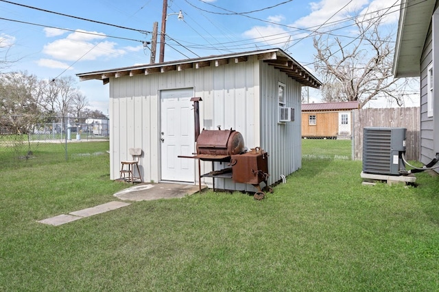 view of shed featuring cooling unit, fence, and central air condition unit