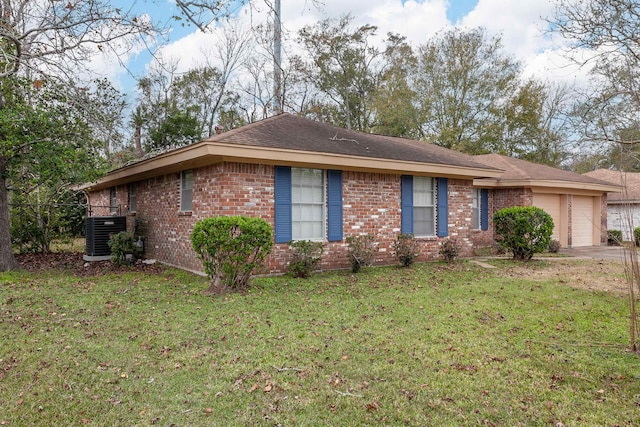 view of front of house featuring central AC, a front yard, and a garage