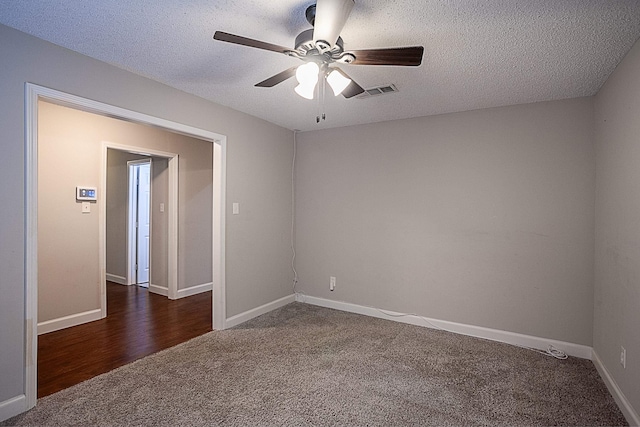 unfurnished room featuring ceiling fan, dark carpet, and a textured ceiling