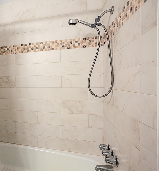 room details with tiled shower / bath combo