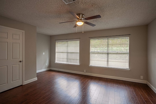 empty room featuring a textured ceiling, ceiling fan, and dark wood-type flooring