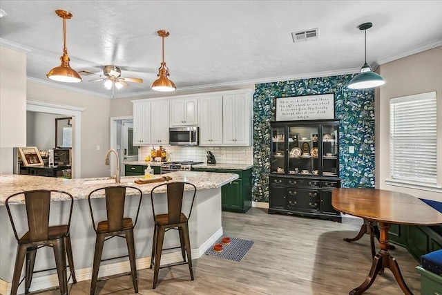 kitchen with white cabinets, sink, ceiling fan, light stone countertops, and appliances with stainless steel finishes