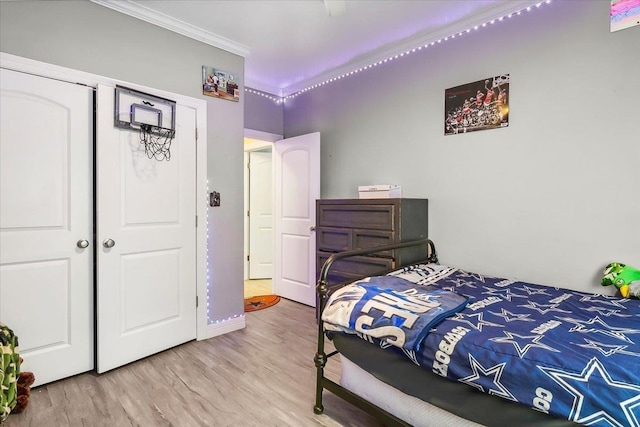 bedroom with hardwood / wood-style floors, a closet, and ornamental molding