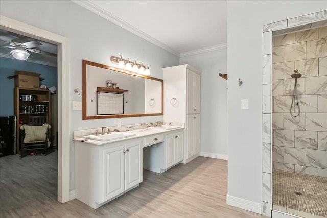 bathroom with hardwood / wood-style floors, vanity, crown molding, ceiling fan, and a tile shower