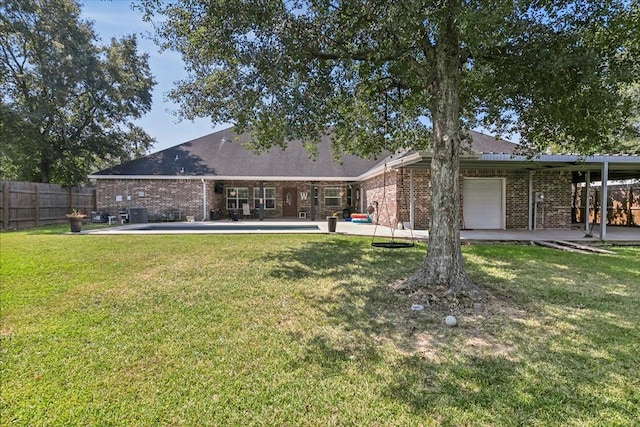 rear view of property with a patio, a garage, and a lawn