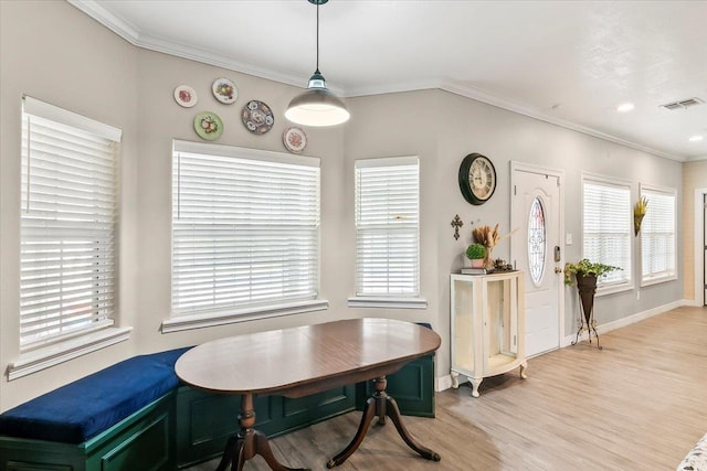 dining area featuring crown molding and light hardwood / wood-style flooring