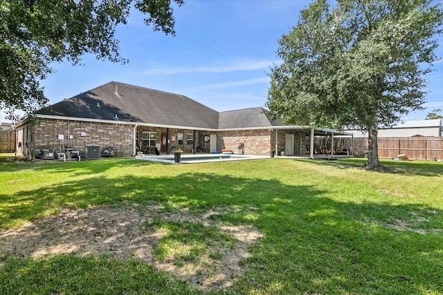 rear view of house with a yard and a patio