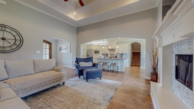 108 Colonial Estates Dr, Bridge City, TX 77611 - living area featuring arched walkways, ceiling fan, light wood finished floors, ornamental molding, and a high ceiling