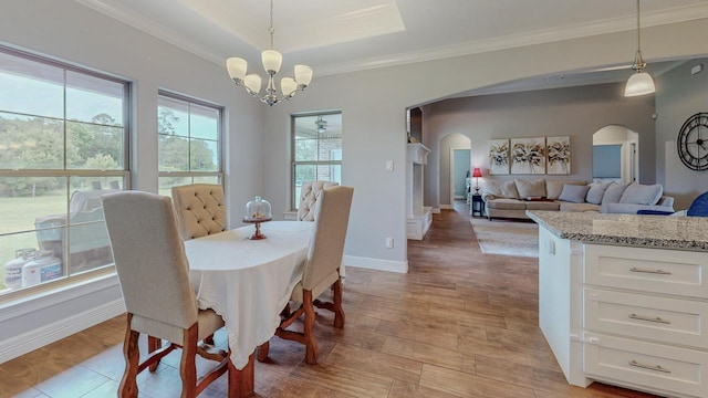108 Colonial Estates Dr, Bridge City, TX 77611 - dining space featuring arched walkways, a chandelier, light wood finished floors, crown molding, and baseboards