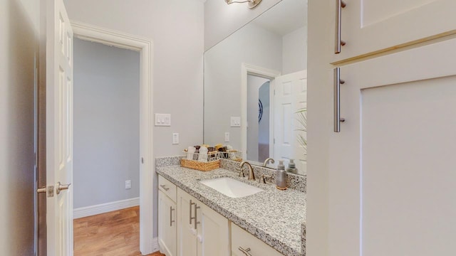 108 Colonial Estates Dr, Bridge City, TX 77611 - bathroom with vanity, wood finished floors, and baseboards