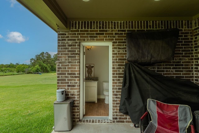 108 Colonial Estates Dr, Bridge City, TX 77611 - view of exterior entry featuring brick siding and a lawn