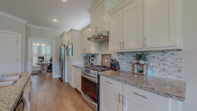 108 Colonial Estates Dr, Bridge City, TX 77611 - kitchen featuring under cabinet range hood, stainless steel appliances, ornamental molding, tasteful backsplash, and light stone counters