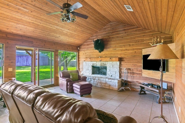 tiled living room with wooden ceiling, a stone fireplace, wooden walls, vaulted ceiling, and ceiling fan