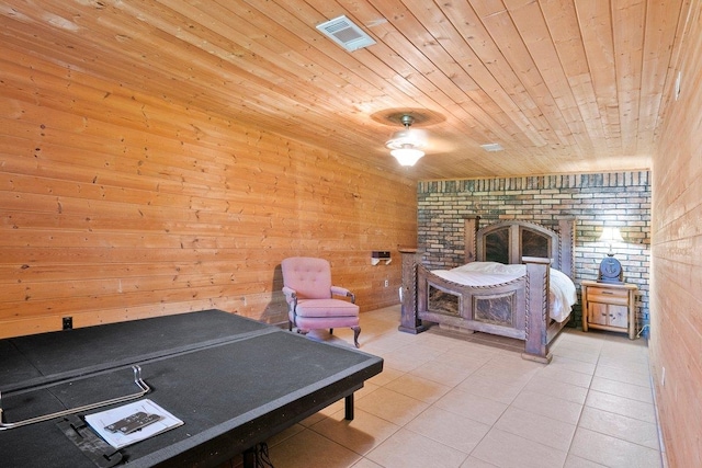 tiled bedroom with wooden walls, ceiling fan, wood ceiling, and brick wall