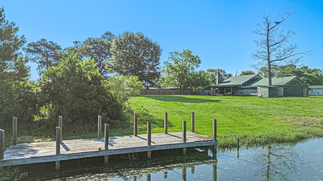 view of dock featuring a water view and a yard