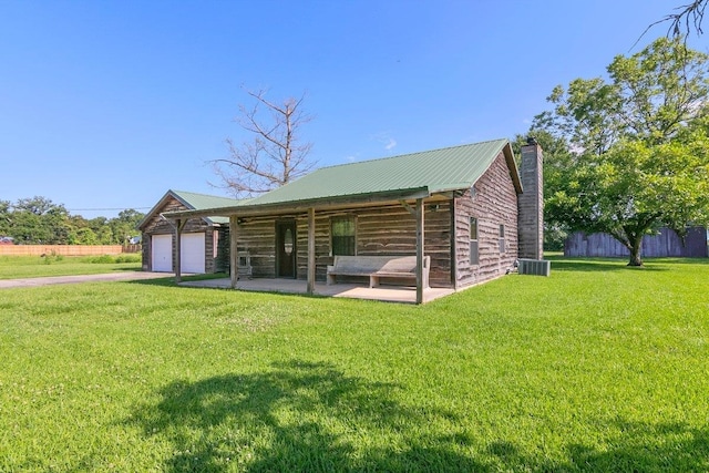 rear view of property featuring a yard and central AC unit