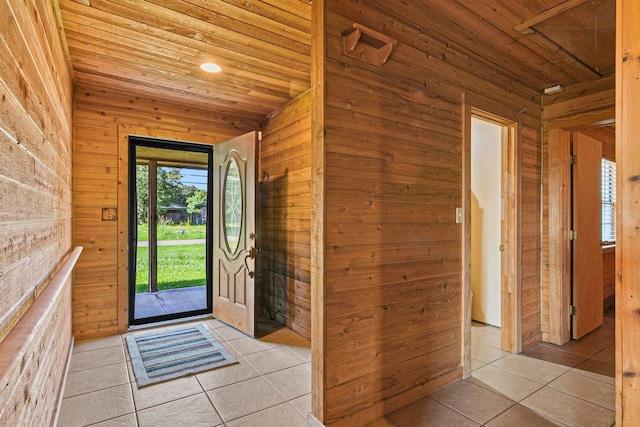 tiled entrance foyer featuring wooden ceiling and wooden walls