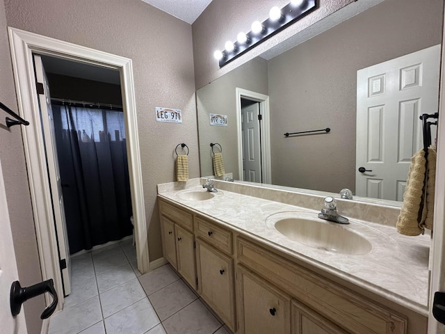 bathroom featuring double vanity, a sink, and a textured wall