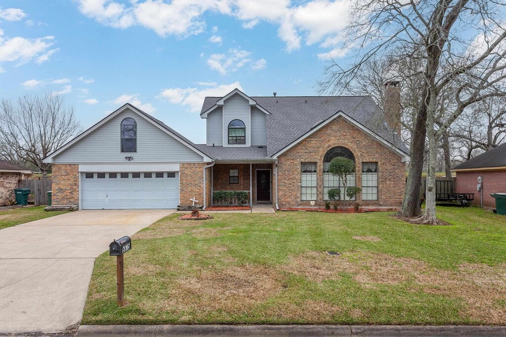 6875 Sierra Cir, Beaumont, TX 77708 - traditional-style house with brick siding, a front lawn, concrete driveway, roof with shingles, and an attached garage