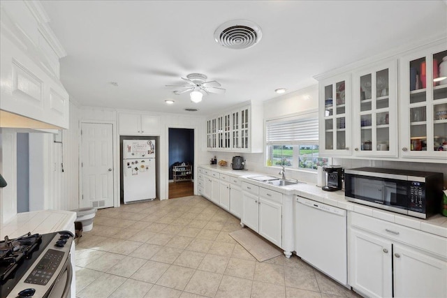 980 N 23rd St, Beaumont, TX 77706 - kitchen featuring white appliances, a sink, white cabinets, tile countertops, and crown molding