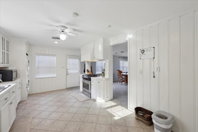 980 N 23rd St, Beaumont, TX 77706 - kitchen featuring stainless steel appliances, a decorative wall, a ceiling fan, light countertops, and white cabinetry