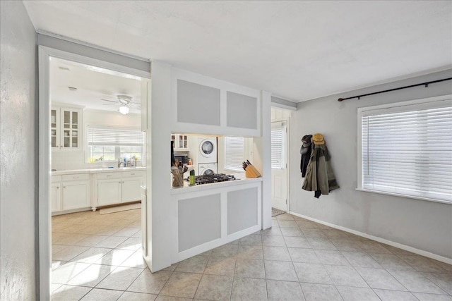 980 N 23rd St, Beaumont, TX 77706 - unfurnished room with stacked washer / drying machine, light tile patterned floors, a ceiling fan, and baseboards