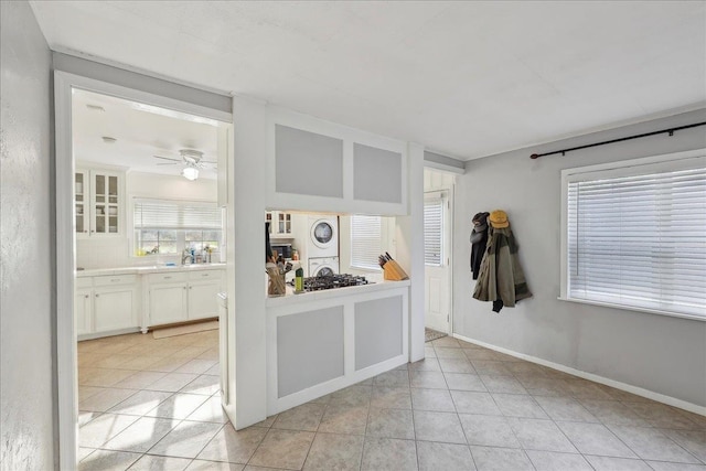 980 N 23rd St, Beaumont, TX 77706 - interior space with stacked washer / dryer, light tile patterned flooring, a ceiling fan, and baseboards
